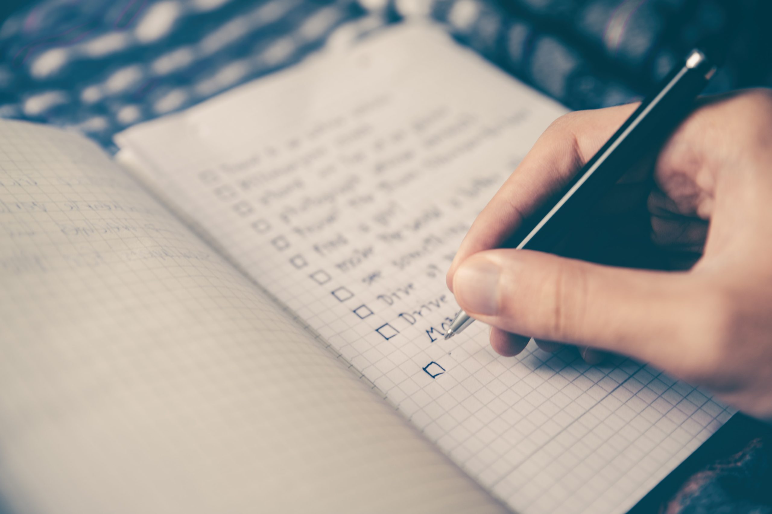 Person writing a list or guidelines in a notebook.